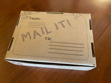 Load image into Gallery viewer, Brown craft box that the button comes in. This is the backside and has Mail It! Written on in along with places to write address and return address so it can be mailed directly in the packaging.
